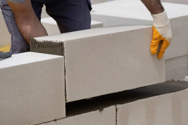 Tuğlacı çalışıyor. Havalandırmalı betondan bir duvar inşa etmek. Gasbeton duvarı