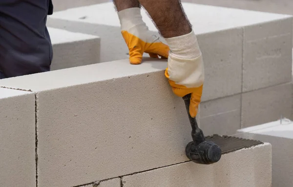 Tuğlacı çalışıyor. Havalandırmalı betondan bir duvar inşa etmek. Gasbeton duvarı