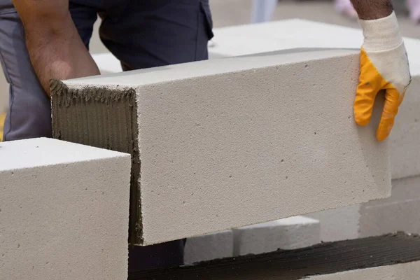Tuğlacı çalışıyor. Havalandırmalı betondan bir duvar inşa etmek. Gasbeton duvarı