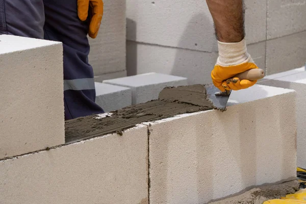 Tuğlacı çalışıyor. Havalandırmalı betondan bir duvar inşa etmek. Gasbeton duvarı