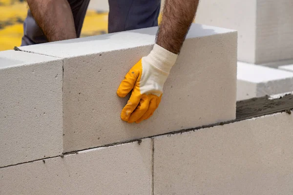 Tuğlacı çalışıyor. Havalandırmalı betondan bir duvar inşa etmek. Gasbeton duvarı