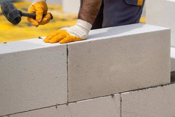 Tuğlacı çalışıyor. Havalandırmalı betondan bir duvar inşa etmek. Gasbeton duvarı