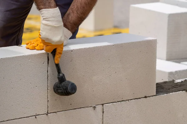 Tuğlacı çalışıyor. Havalandırmalı betondan bir duvar inşa etmek. Gasbeton duvarı