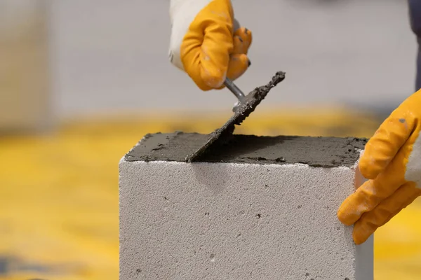 Tuğlacı çalışıyor. Havalandırmalı betondan bir duvar inşa etmek. Gasbeton duvarı