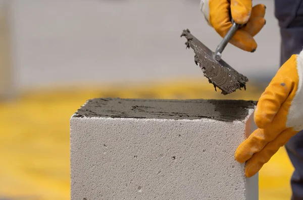 Tuğlacı çalışıyor. Havalandırmalı betondan bir duvar inşa etmek. Gasbeton duvarı