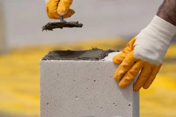 Tuğlacı çalışıyor. Havalandırmalı betondan bir duvar inşa etmek. Gasbeton duvarı