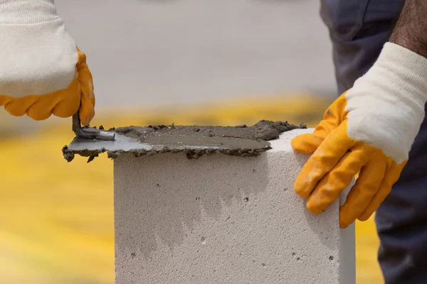Tuğlacı çalışıyor. Havalandırmalı betondan bir duvar inşa etmek. Gasbeton duvarı