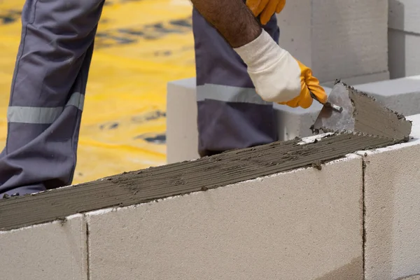 Tuğlacı çalışıyor. Havalandırmalı betondan bir duvar inşa etmek. Gasbeton duvarı