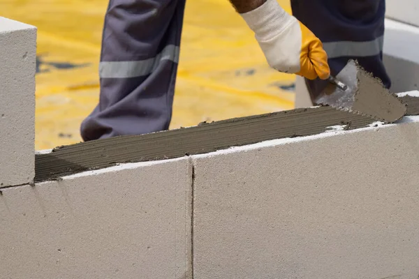 Tuğlacı çalışıyor. Havalandırmalı betondan bir duvar inşa etmek. Gasbeton duvarı