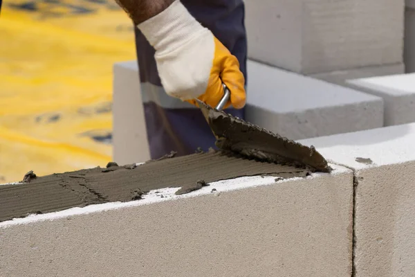 Tuğlacı çalışıyor. Havalandırmalı betondan bir duvar inşa etmek. Gasbeton duvarı