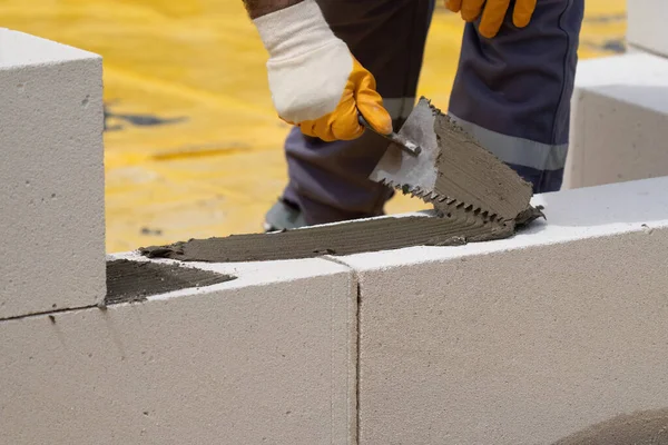 Tuğlacı çalışıyor. Havalandırmalı betondan bir duvar inşa etmek. Gasbeton duvarı
