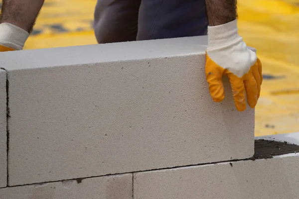 Tuğlacı çalışıyor. Havalandırmalı betondan bir duvar inşa etmek. Gasbeton duvarı