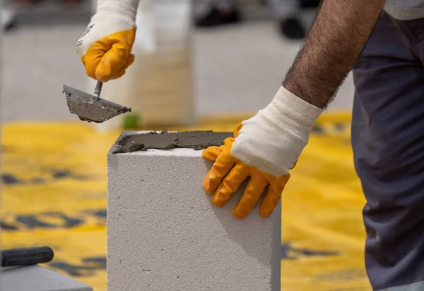 Tuğlacı çalışıyor. Havalandırmalı betondan bir duvar inşa etmek. Gasbeton duvarı