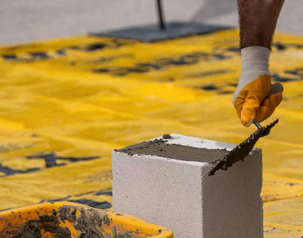 Tuğlacı çalışıyor. Havalandırmalı betondan bir duvar inşa etmek. Gasbeton duvarı