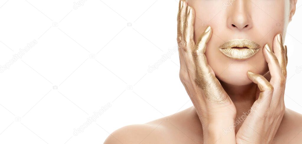 Gold based  skincare concept. Beautiful model girl with gold treatment on a flawless skin posing with hands on cheeks. Close up beauty portrait isolated on white