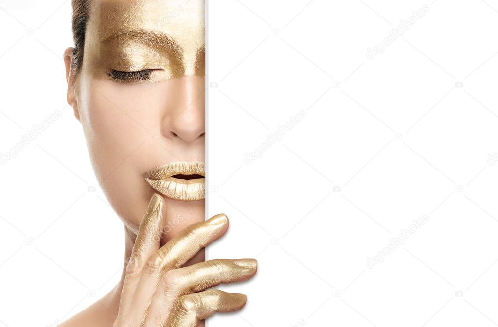 Gold beauty makeup and nail art concept with a half portrait of a woman wearing gold cosmetics on her eye, lips and fingers as she holds a white card to the side. Isolated on white with copy space