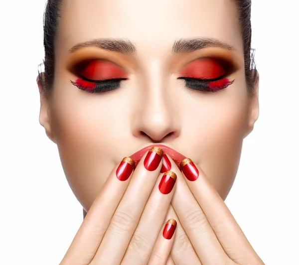 Schöne Mädchen in rot mit den Händen auf dem Gesicht. Nagelkunst und Makeu — Stockfoto