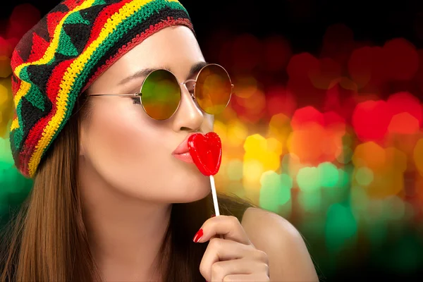 Menina da festa elegante beijando um pirulito em forma de coração — Fotografia de Stock