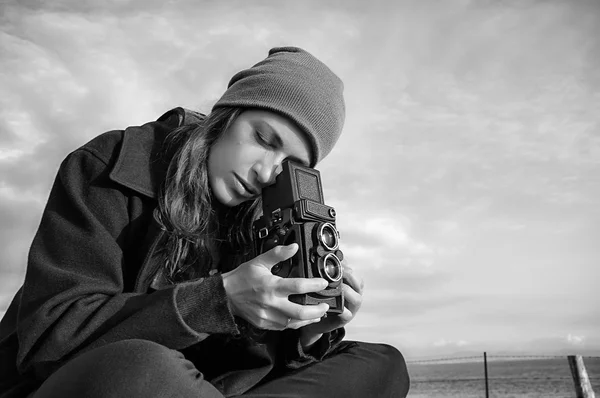 Молодая женщина фотограф с помощью винтажной камеры на открытом воздухе — стоковое фото