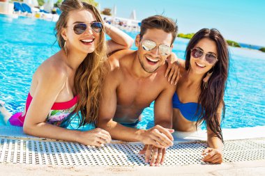 Yüzme havuzunda gülümseyen insanlar