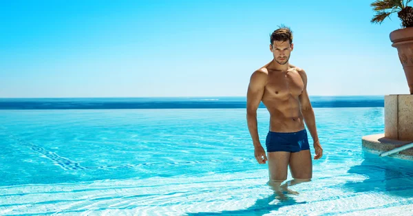 Hombre musculoso en la piscina posando — Foto de Stock