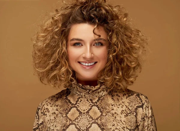Portrét Mladé Usmívající Ženy Kudrnatými Vlasy Hnědém Pozadí — Stock fotografie