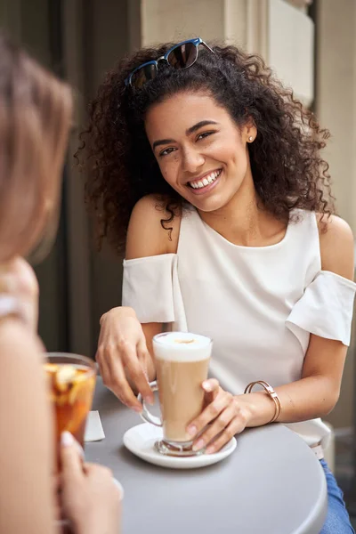 一个美丽的微笑的拉丁裔美国女孩的画像 在见面时喝拿铁 — 图库照片