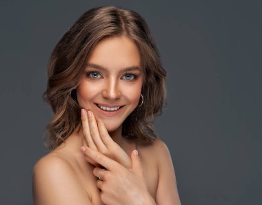 Beyaz dişli, çenesi dokunaklı neşeli genç mankenin portresi.