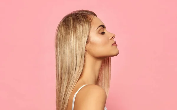 Portrait of profile face of sexy blonde woman on pink background