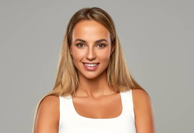 Gri arka planda izole güzel sarışın kadın.