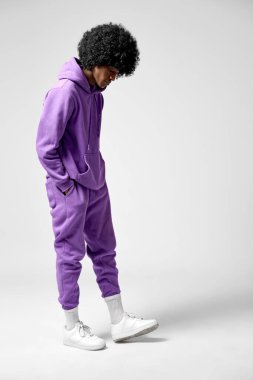 Genç Afrikalı adam beyaz arka planda izole edilmiş eşofman giyiyor.