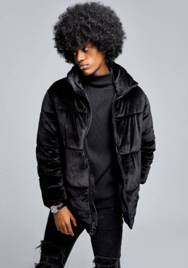 Kışlık ceketli yakışıklı Afrikalı Amerikalı adam gri arka planda izole edilmiş.