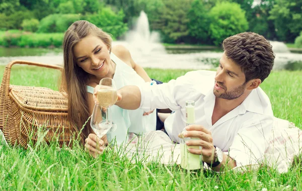 Casal feliz no piquenique beber vinho branco — Fotografia de Stock