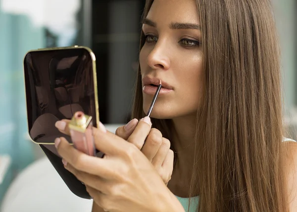 Donna che mette rossetto e si guarda allo specchio — Foto Stock