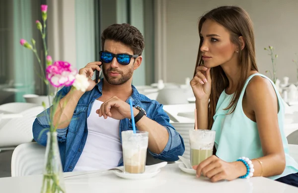 Yakışıklı adam akıllı telefonda konuşurken güzel kadınla — Stok fotoğraf