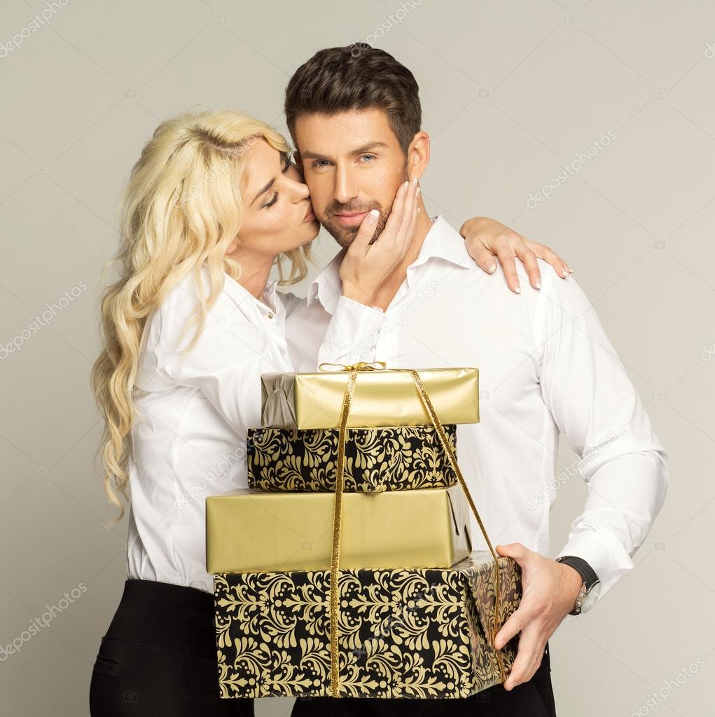 Woman kissing man with gifts