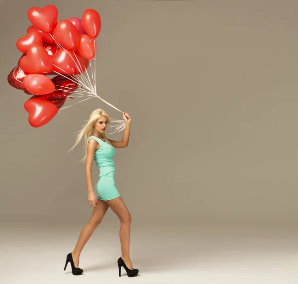 Веселая женщина с красными воздушными шарами — стоковое фото