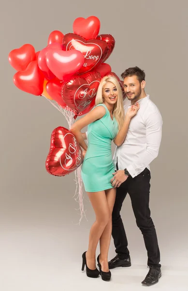 Loving couple with red balloons — Stock Photo, Image