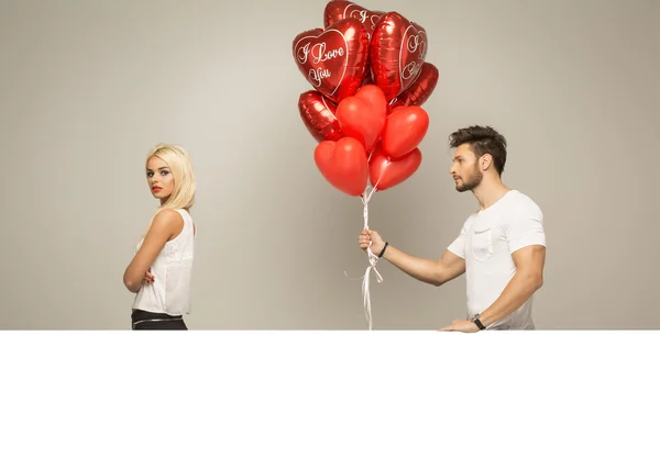 Attractive couple with red balloons — Stok fotoğraf
