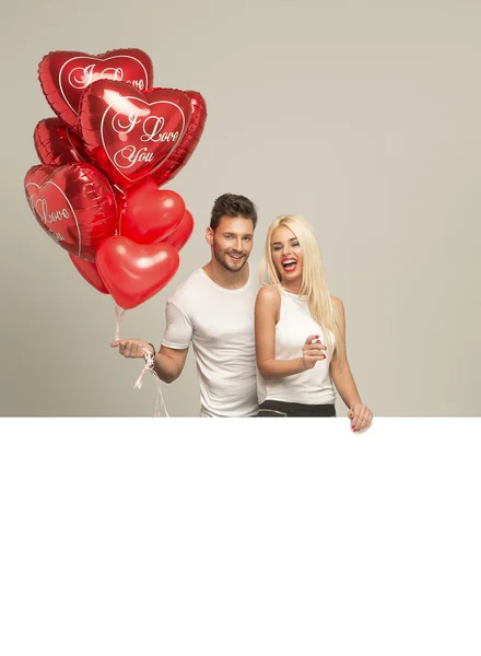 Casal atraente com balões vermelhos — Fotografia de Stock