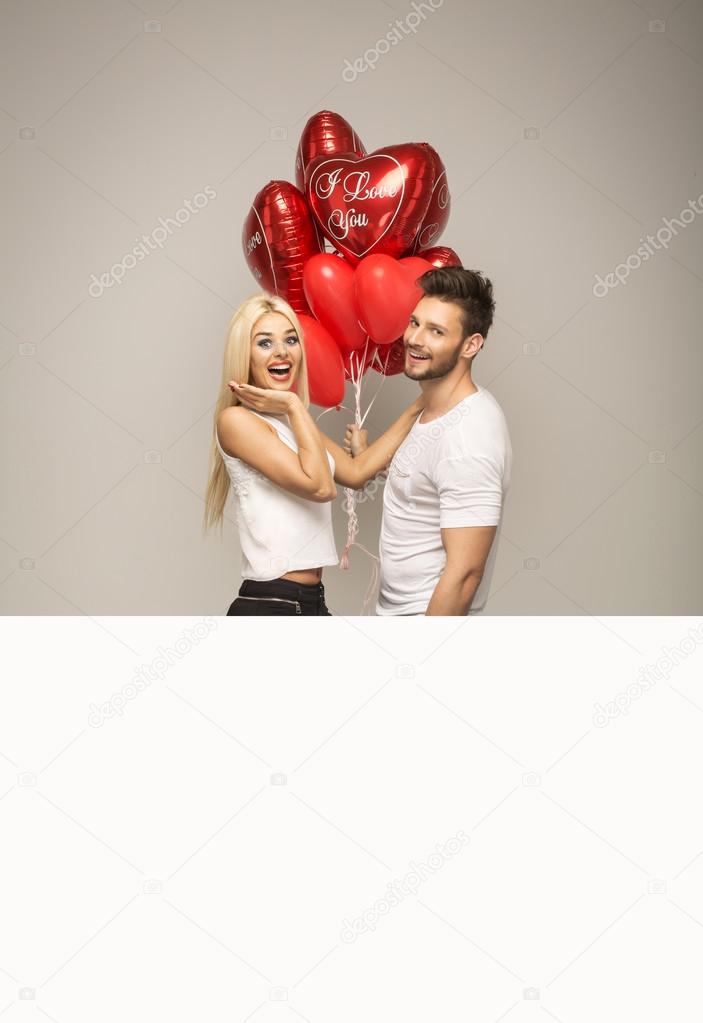 Attractive couple with red balloons