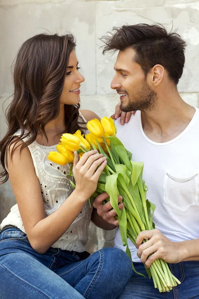 Homem dando flores ela namorada — Fotografia de Stock