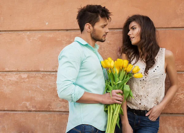 Hombre dando un tulipanes mujer joven — Foto de Stock