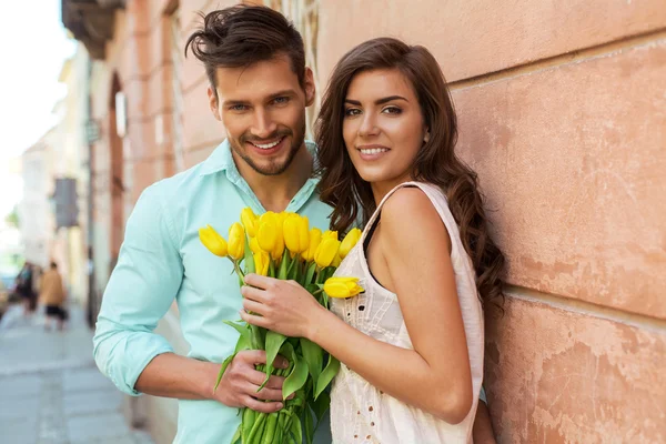 Pareja feliz con tulipanes amarillos — Foto de Stock