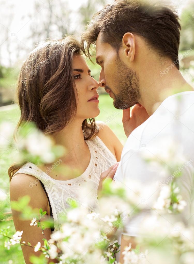 Kissing couple in the blooming garden