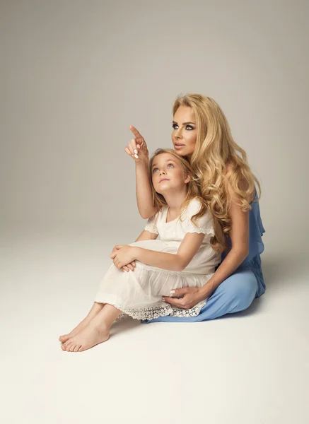 Mother showing empty space to daughter — Stock Photo, Image