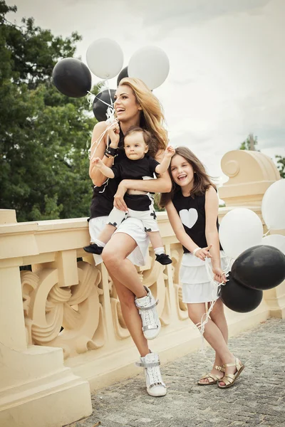 Mãe com filhos se divertindo com balões — Fotografia de Stock