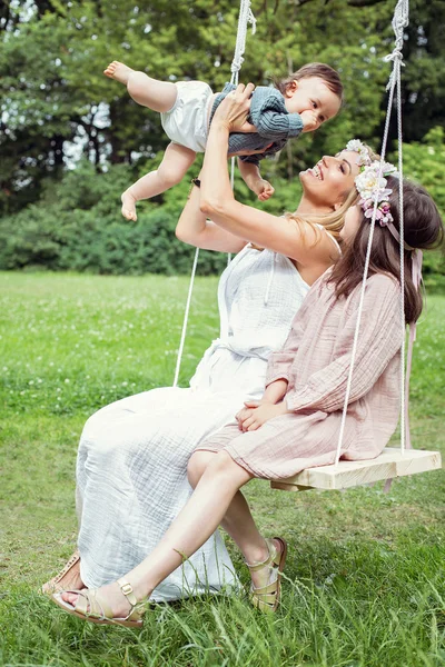 Мати і діти сидять на гойдалці — стокове фото