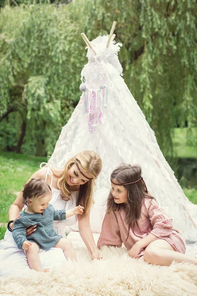 Moeder en kinderen zijn zit in een Tipi tent en plezier — Stockfoto