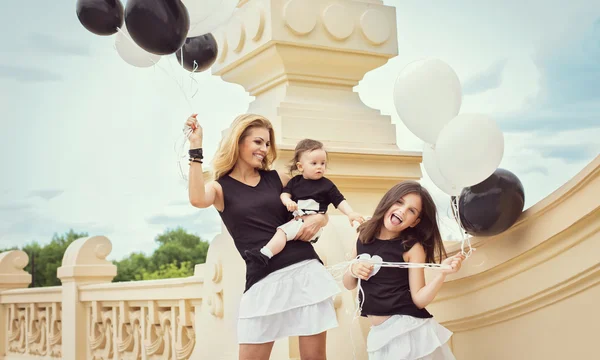 Mamma med barn att ha en kul med baloons — Stockfoto